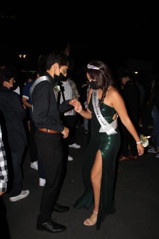 Homecoming Princess Daisy Razon and Prince Joshua Robles wearing their masks while on the dance floor 